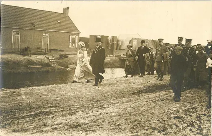 Koningin Wilhelmina, in gezelschap van burgemeester Albert Vriend van Odoorn, op weg naar de woning van Derk en Janneke van der Leij