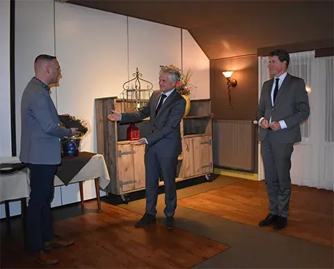 De burgemeesters van de gemeenten Westerwolde, Jaap Velema (midden) en Emmen, Eric van Oosterhout (rechts) ontvangen uit handen van auteur Albert Eggens het eerste exemplaar.