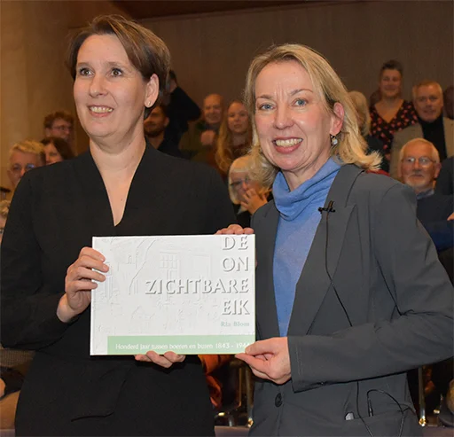Ria Blom heeft het eerste exemplaar van De Onzichtbare Eik aan Ankie van Tongeren, wethouder gemeente Borger-Odoorn, overhandigd.